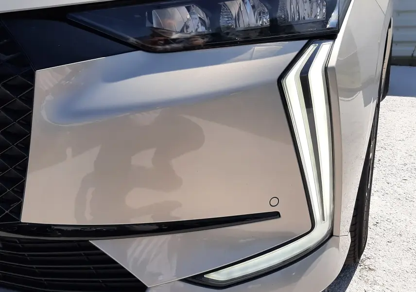 Gros plan sur le phare avant droit du DS4 2024 en Cristal Pearl, mettant en valeur ses feux LED distinctifs en forme de dents.