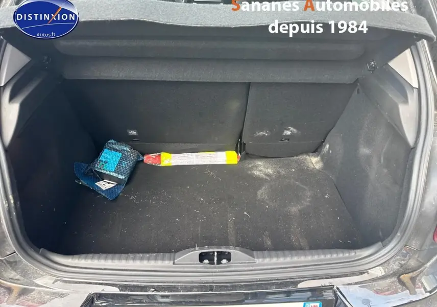 Coffre ouvert d'une Citroën C3 noire 2023, vue arrière montrant l'espace de chargement avec quelques objets à l'intérieur.