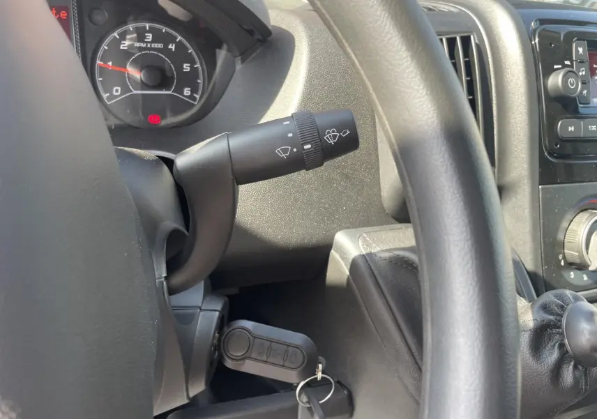 Vue rapprochée de l'intérieur du Citroën Jumper 2023 montrant le volant, le compteur et la clé de contact insérée.