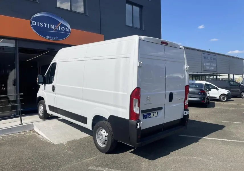 Vue 3/4 arrière droite d'un utilitaire blanc Citroën Jumper 2023 avec portes arrière tôlées et jantes acier.