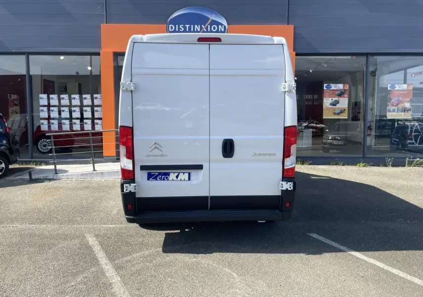Vue arrière d'un utilitaire Citroën Jumper blanc 2023 avec portes battantes tôlées et logo distinctif sur parking.