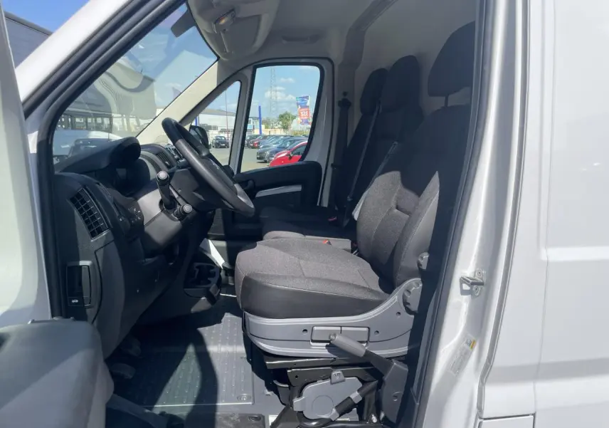 Vue intérieure côté conducteur du Citroën Jumper blanc 2023, montrant les sièges avant et le tableau de bord.