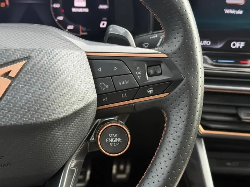 Gros plan sur le volant perforé noir et les commandes multifonctions avec bouton Start Engine du CUPRA Formentor blanc Nevada 2025.