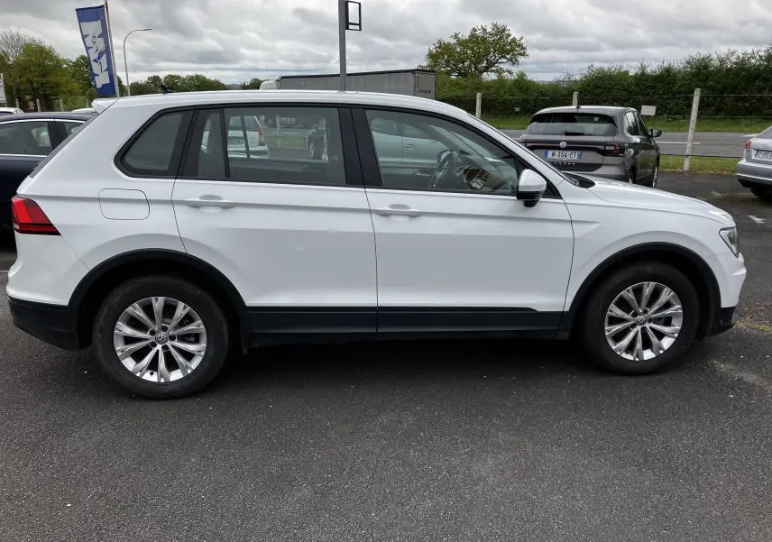 Vue latérale côté droit d'un Volkswagen Tiguan blanc 2018 avec jantes alliage et protections noires basses.