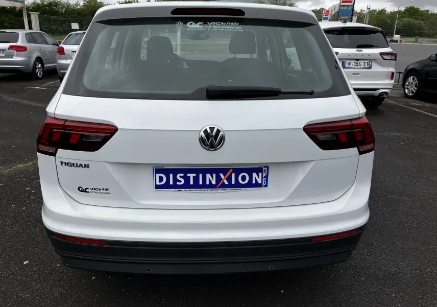 Vue arrière d'un Volkswagen Tiguan blanc de 2018 avec logo et plaque d'immatriculation Distinxion visible.