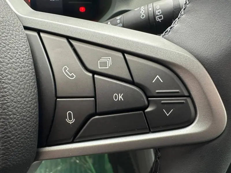 Gros plan sur les commandes multifonctions noires à droite du volant du Dacia Duster 2025, finition Microcloud noire.