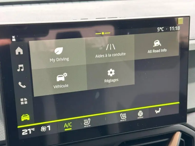 Écran tactile central du tableau de bord du Dacia Duster blanc 2025 affichant les menus d’aide à la conduite et réglages