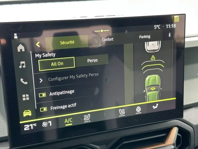 Écran tactile du tableau de bord du Dacia Duster blanc 2025 affichant les options de sécurité et de parking