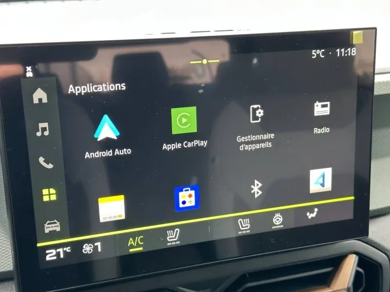 Écran tactile intérieur du Dacia Duster blanc 2025 affichant les applications Android Auto et Apple CarPlay.
