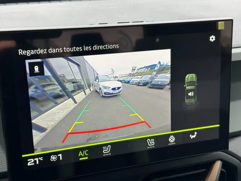 Écran tactile montrant la caméra de recul du Dacia Duster blanc 3/4 arrière avec lignes de guidage colorées