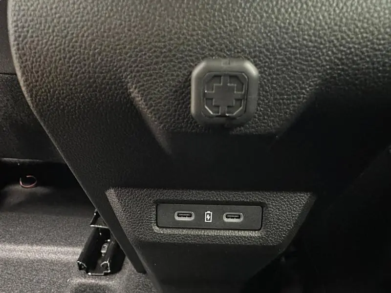 Prise USB-C double en gros plan sur la console centrale arrière du Dacia Duster blanc 2025.