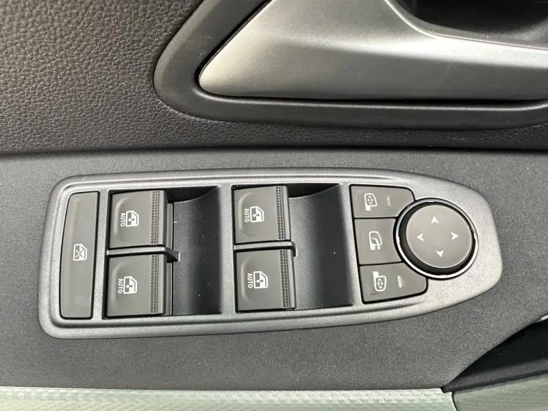 Panneau de commandes des vitres et rétroviseurs côté conducteur du Dacia Duster blanc 2025, intérieur noir.