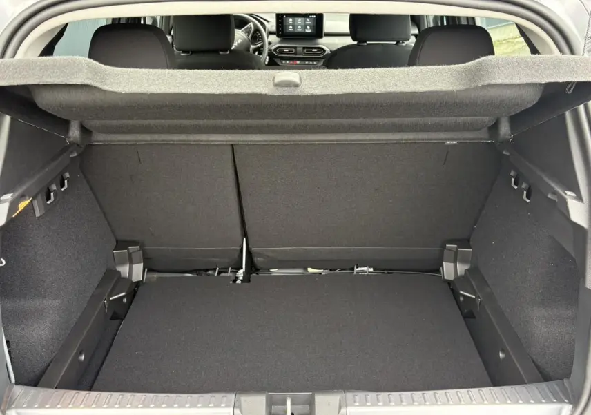 Coffre ouvert vu de l'arrière d'une Dacia Sandero Stepway 2025, intérieur noir avec tablette de coffre relevée.