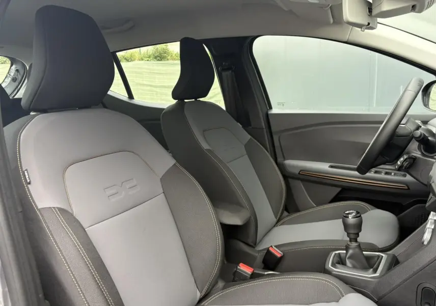 Vue intérieure côté droit des sièges avant gris clair et foncé de la Dacia Sandero Stepway TCE 110 Extrême 2025.