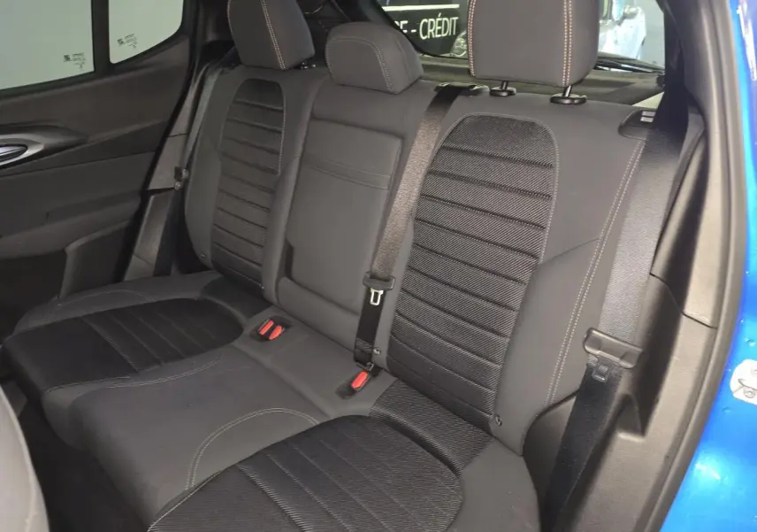 Vue intérieure de la banquette arrière noire avec surpiqûres beige de l'Alfa Romeo Tonale bleu, côté droit ouvert.