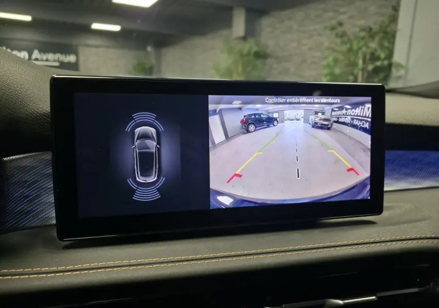 Écran intérieur affichant la caméra de recul et les capteurs de stationnement d’une Alfa Romeo Tonale bleu, vue avant.