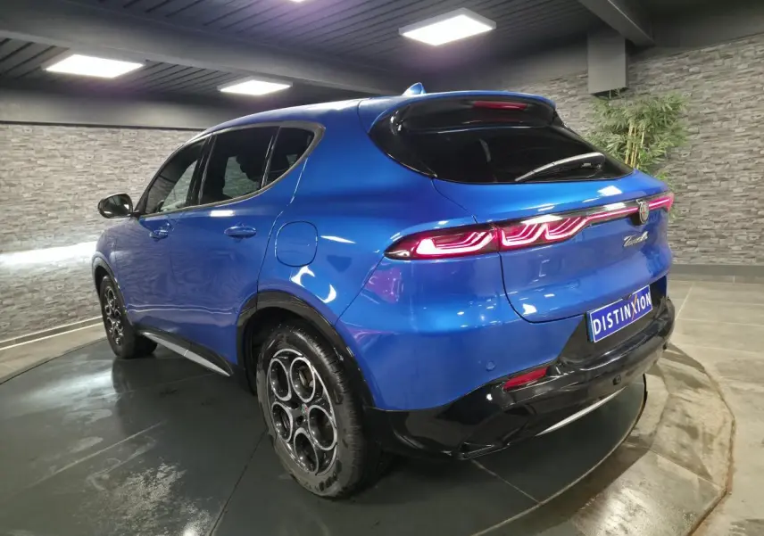 Vue 3/4 arrière droite de l'Alfa Romeo Tonale bleu métallisé avec feux arrière LED et jantes alliage 18 pouces.