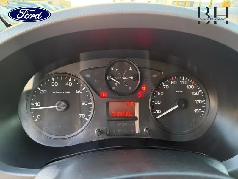 Vue rapprochée du tableau de bord d'un Citroën Berlingo blanc, affichant les compteurs et témoins lumineux allumés.