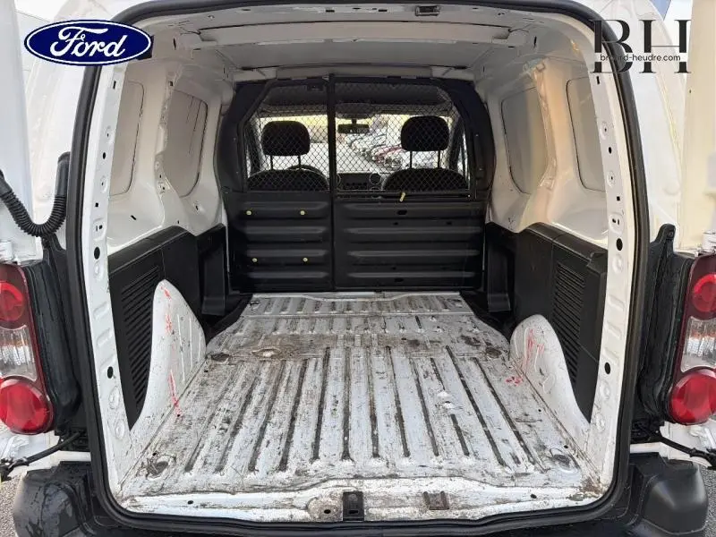 Vue arrière intérieure du coffre blanc du Citroën Berlingo M 1.6 VTi 95 Confort avec cloison tubulaire noire.