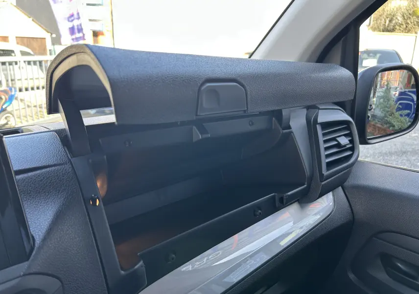 Gros plan sur la prise 12V et le bouton de désactivation de l'airbag passager dans le rangement intérieur du Citroën Jumpy Cabine Approfondie noir.