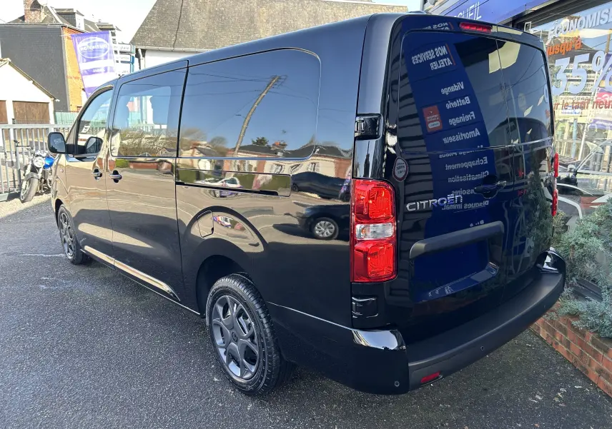 Vue 3/4 arrière droite d’un Citroën Jumpy Cabine Approfondie noir métallisé avec jantes tôle noires et porte latérale coulissante.