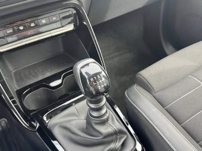 Vue rapprochée du levier de vitesses manuel noir dans l’habitacle de la Citroën C3 1.2 Turbo 2025, sièges gris visibles.