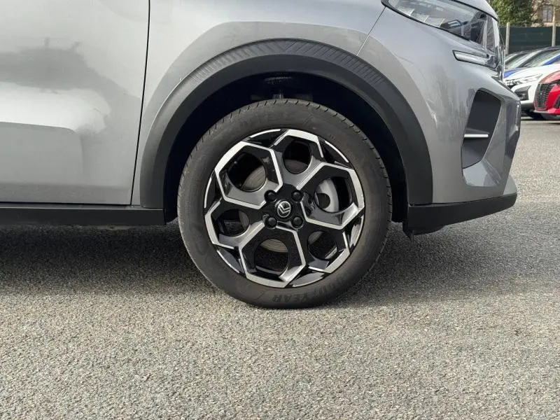 Gros plan sur la roue avant droite de la Citroën C3 1.2 Turbo 100ch MAX 2025 en Gris Mercury avec jante noire et argent.