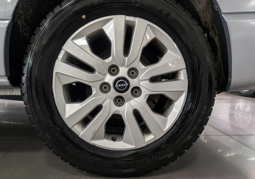 Gros plan sur la roue avant droite du Nissan Primastar Combi gris Highland, mettant en valeur la jante alliage et le pneu Falken.