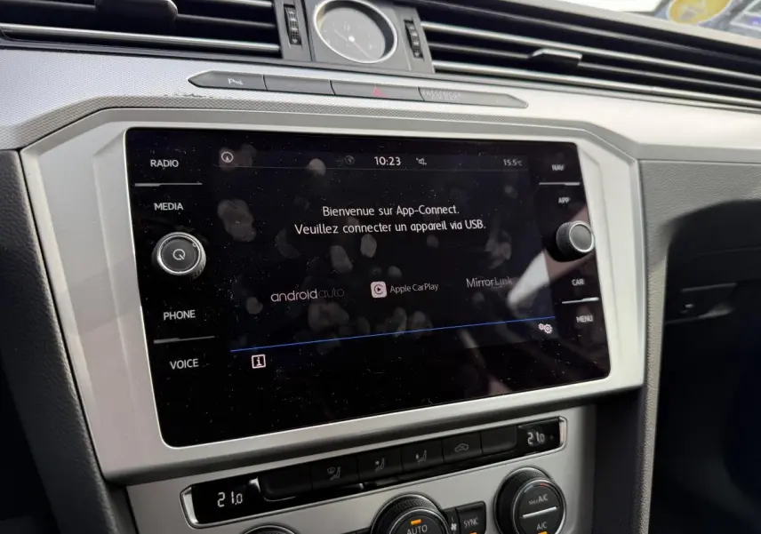 Vue rapprochée de la console centrale argentée de la Volkswagen Passat noire 2018 avec écran tactile et horloge analogique.