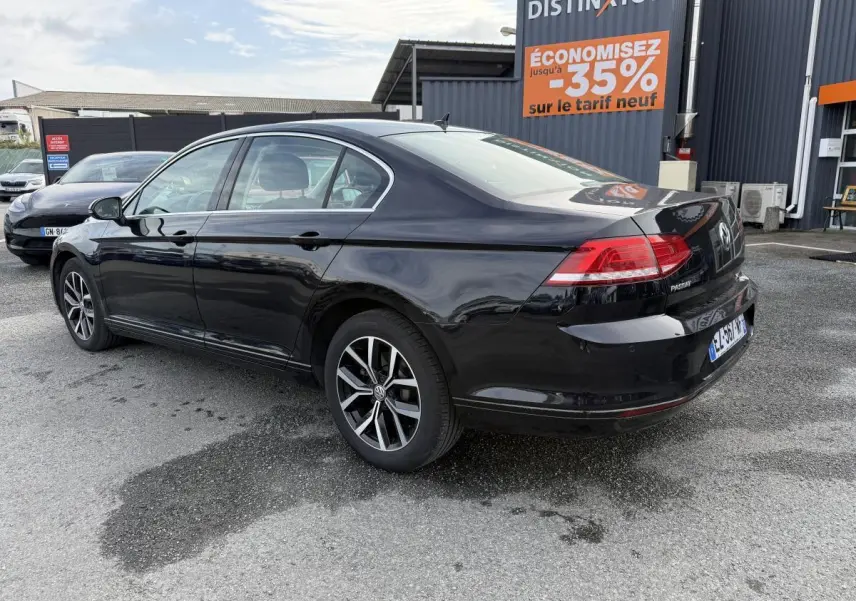 Volkswagen Passat noire vue en 3/4 arrière côté droit, avec jantes alliage et feux arrière LED visibles.