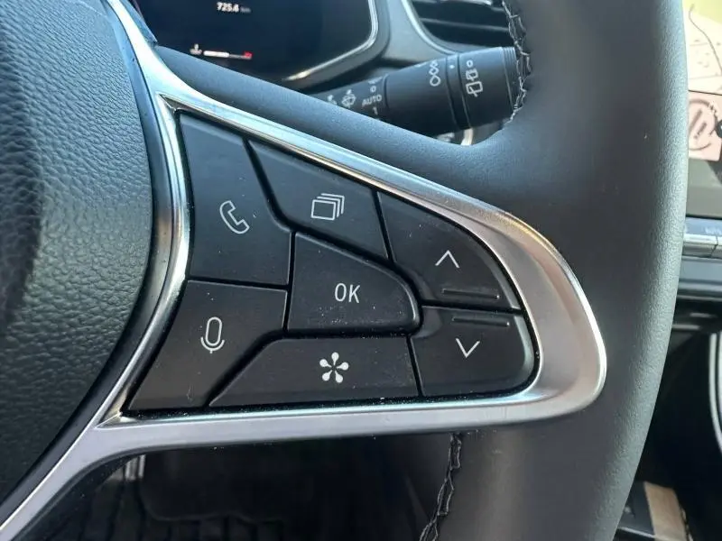 Gros plan sur les commandes multifonctions à droite du volant du Renault Captur 2025, finition noire avec contour chromé.