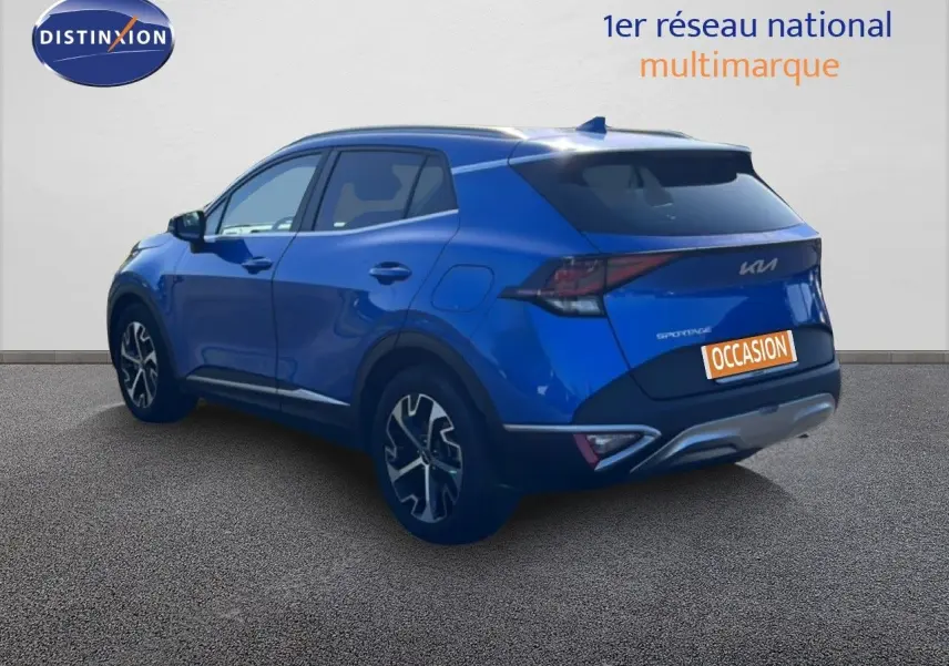 Vue 3/4 arrière droite d'un Kia Sportage bleu fusion métal avec jantes alliage et feux arrière LED.