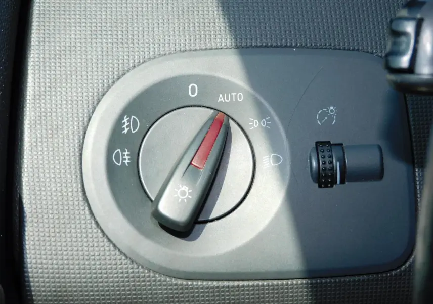 Gros plan sur le sélecteur d'éclairage intérieur gris du tableau de bord d'une SEAT Ibiza Cupra noire.