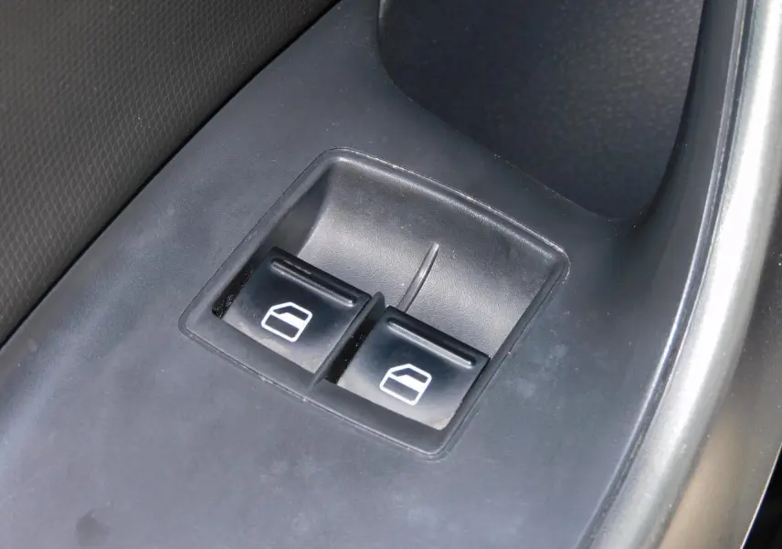 Gros plan sur les boutons de commande des vitres électriques côté conducteur d'une SEAT Ibiza Cupra noire.