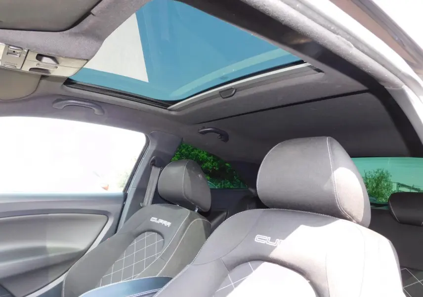 Intérieur noir de la SEAT Ibiza Cupra 2011 vu côté conducteur, avec toit ouvrant transparent et sièges sport Cupra.