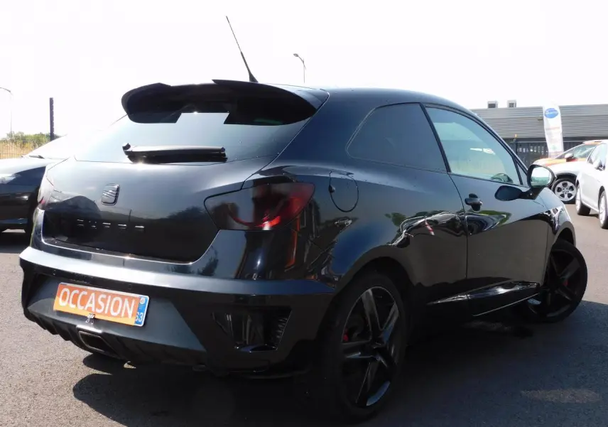 SEAT Ibiza Cupra noire vue 3/4 arrière droit, avec jantes noires et becquet de toit sportif.