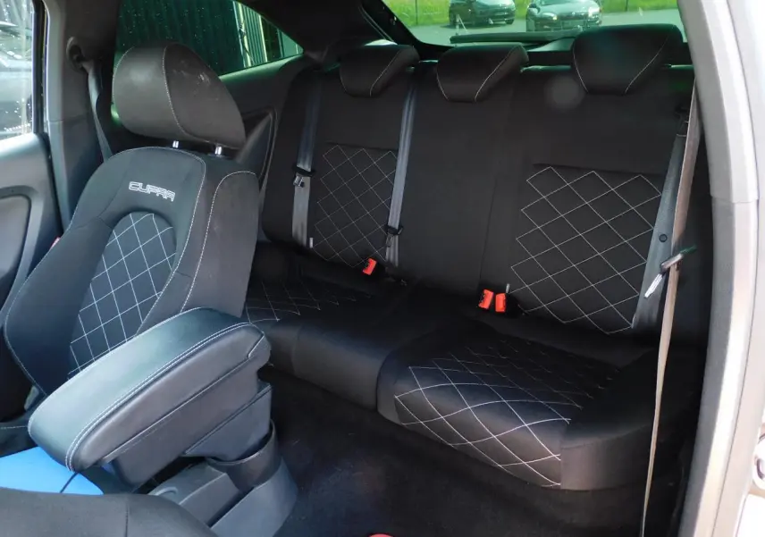 Vue intérieure arrière de la SEAT Ibiza Cupra noire, sièges sport avec surpiqûres et logo Cupra brodé.