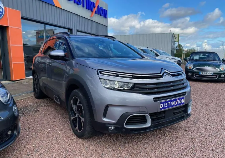 SUV Citroën C5 Aircross gris Artense vu en 3/4 avant droit avec calandre distinctive et jantes noires.