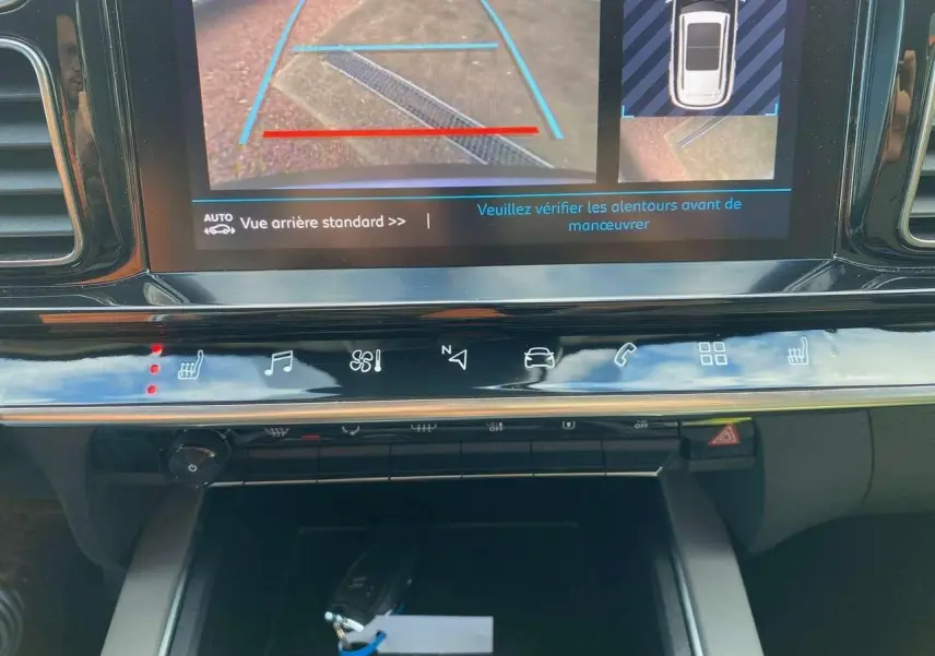 Gros plan sur l'écran tactile et la console centrale du Citroën C5 Aircross gris, affichant la caméra de recul en marche.