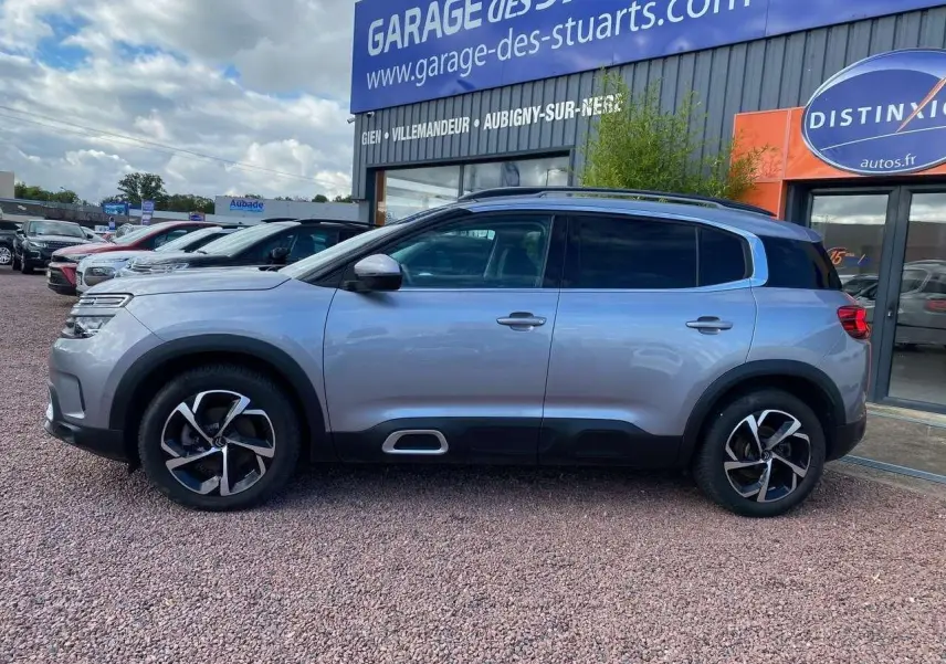 Profil côté gauche du Citroën C5 Aircross gris Artense avec vitres surteintées et jantes noires bicolores.