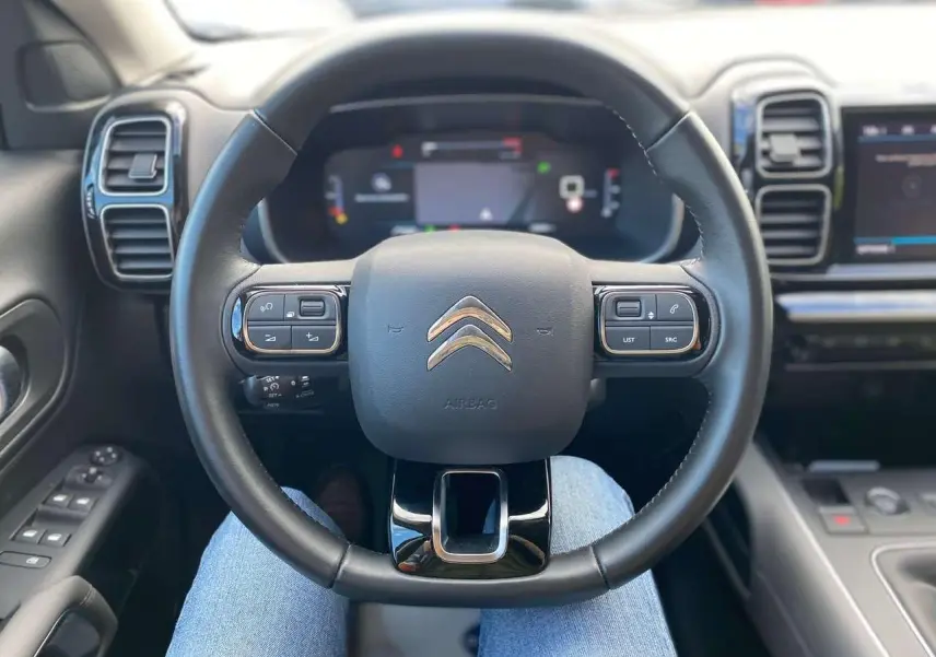 Vue centrée sur le volant cuir noir du Citroën C5 Aircross 2021 avec tableau de bord numérique et commandes intégrées.
