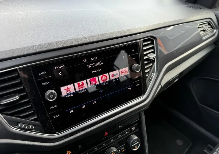 Vue intérieure du tableau de bord du Volkswagen T-Roc 2020 avec écran tactile et commandes de climatisation noires.