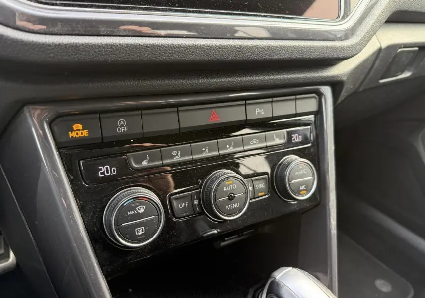 Détail de la console centrale noire du Volkswagen T-Roc 2020 avec commandes de climatisation automatique et bouton mode actif.