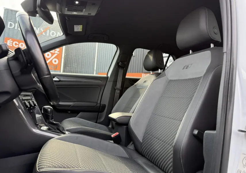 Intérieur avant du Volkswagen T-Roc R-Line 2020, sièges sport gris avec logo R brodé, volant et console visibles.