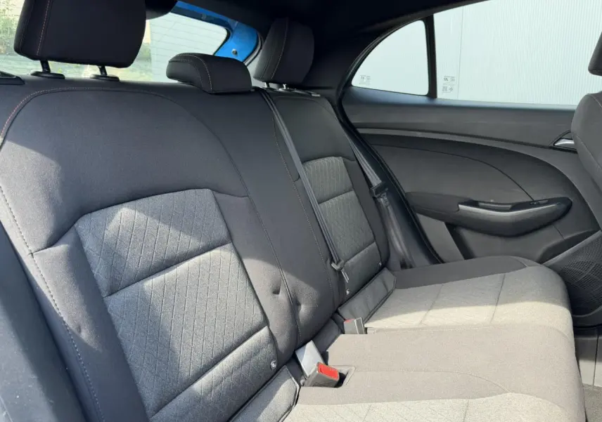 Vue intérieure des sièges arrière en tissu noir de la MG3 1.5 Hybrid+ 195 Comfort, avec ceinture et porte latéral côté droit.
