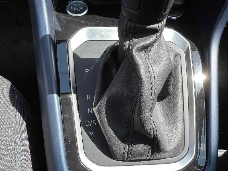 Gros plan sur le levier de vitesse automatique cuir noir du Volkswagen T-Roc 1.5 TSI gris, avec indication des modes P, R, N, D/S.