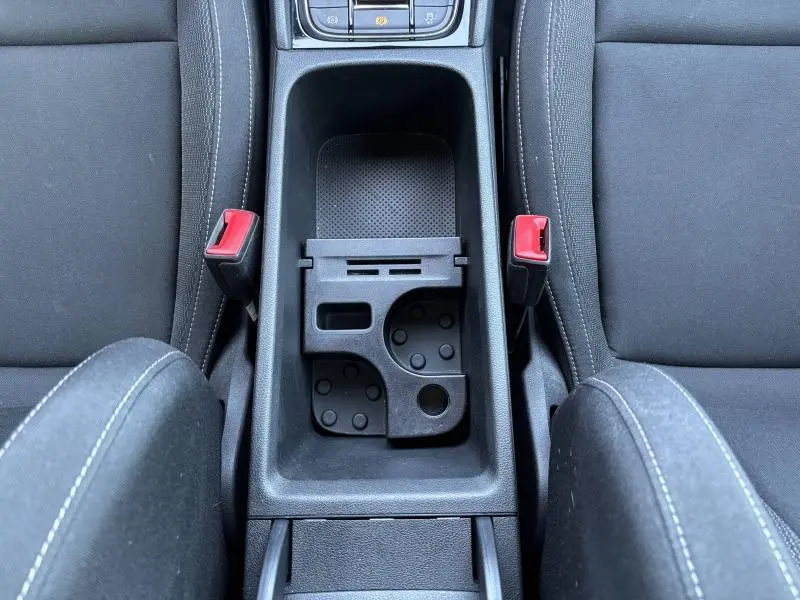 Vue plongeante sur la console centrale noire entre les sièges tissu noir du Skoda Karoq blanc Lune 2024