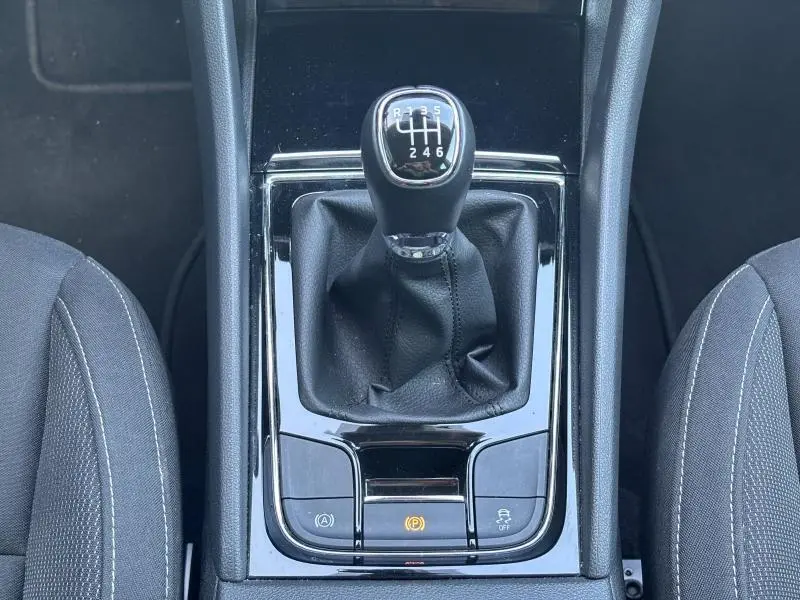 Vue rapprochée du levier de vitesses manuel noir entouré des commandes sur la console centrale du Skoda Karoq 2024.