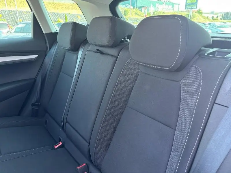 Vue intérieure sur la banquette arrière noire du Skoda Karoq 2024, tissu avec surpiqûres blanches visibles.
