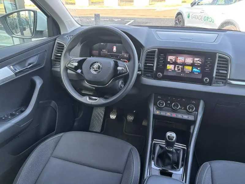 Intérieur du SKODA KAROQ 2024 vue avant, tableau de bord noir avec écran tactile et volant cuir multifonction.